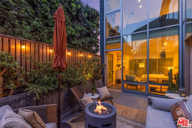 patio terrace at dusk featuring an outdoor fire pit