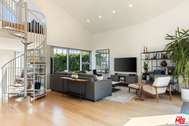 living room featuring light hardwood / wood-style flooring and a high ceiling