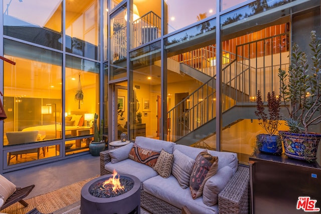 patio terrace at dusk featuring an outdoor living space with a fire pit