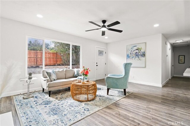 living room with wood-type flooring and ceiling fan