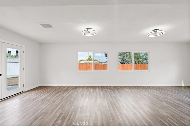 unfurnished room with hardwood / wood-style flooring