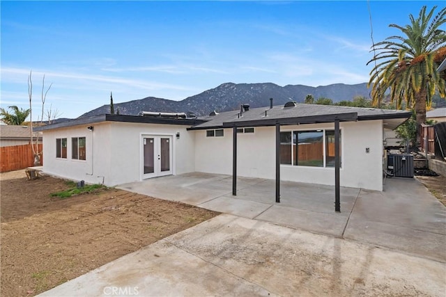 rear view of property with french doors, a mountain view, and a patio