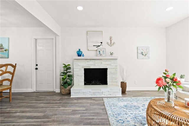 living room featuring hardwood / wood-style floors and a stone fireplace