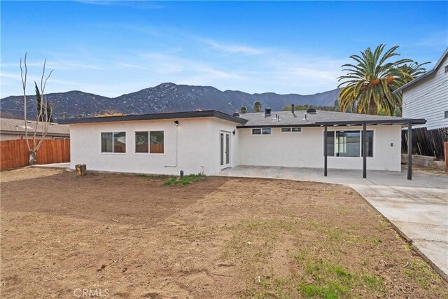 rear view of property featuring a mountain view and a patio area