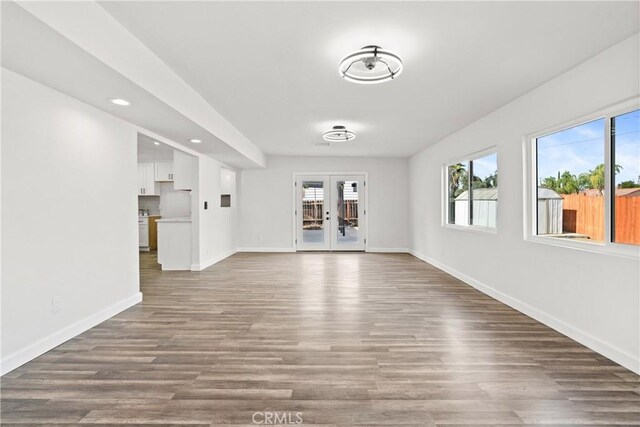 unfurnished living room with wood-type flooring and french doors