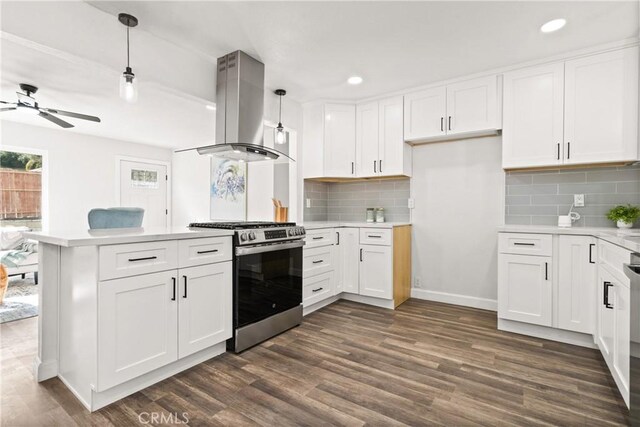 kitchen with hanging light fixtures, white cabinets, island exhaust hood, dark hardwood / wood-style flooring, and gas range