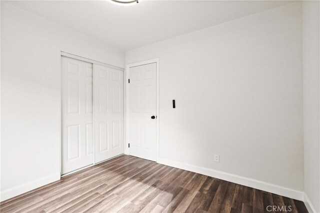 unfurnished bedroom featuring hardwood / wood-style floors and a closet