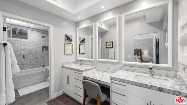 full bathroom with vanity, hardwood / wood-style flooring, toilet, and tiled shower / bath