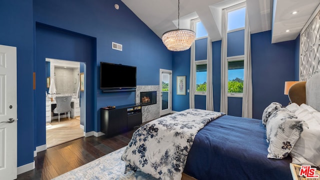 bedroom with multiple windows, dark hardwood / wood-style floors, a notable chandelier, and high vaulted ceiling