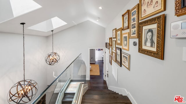 corridor with a notable chandelier, a skylight, high vaulted ceiling, and dark hardwood / wood-style floors