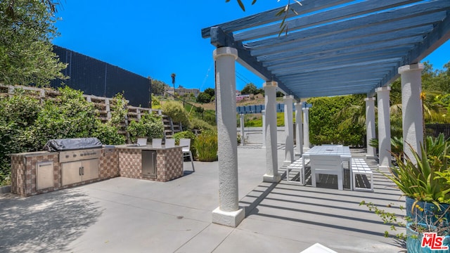 view of patio with area for grilling, a pergola, and grilling area