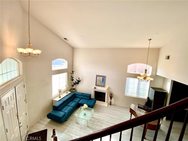 living area with a chandelier, visible vents, and a healthy amount of sunlight