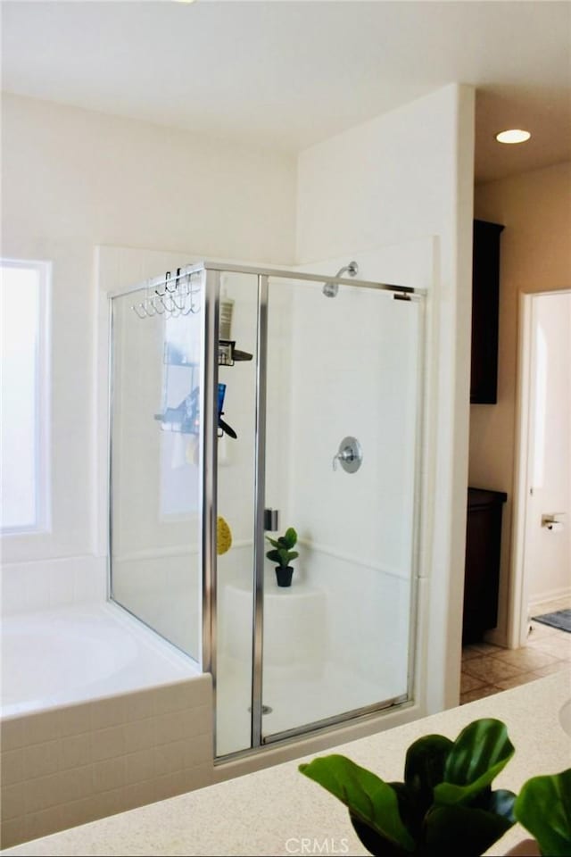 bathroom with a shower stall and a bath