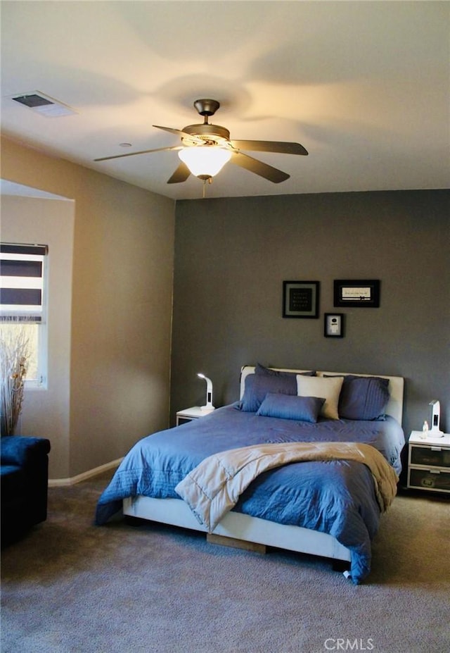 carpeted bedroom featuring ceiling fan, visible vents, and baseboards