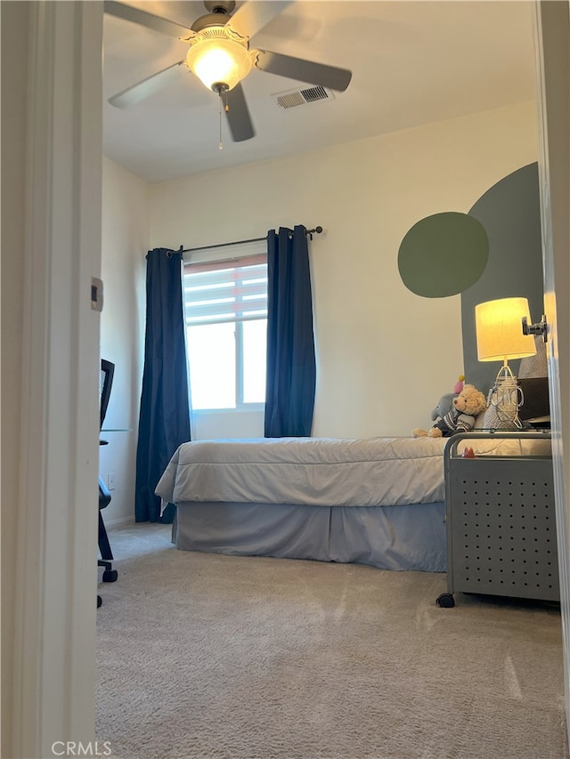 bedroom with ceiling fan, visible vents, and light colored carpet