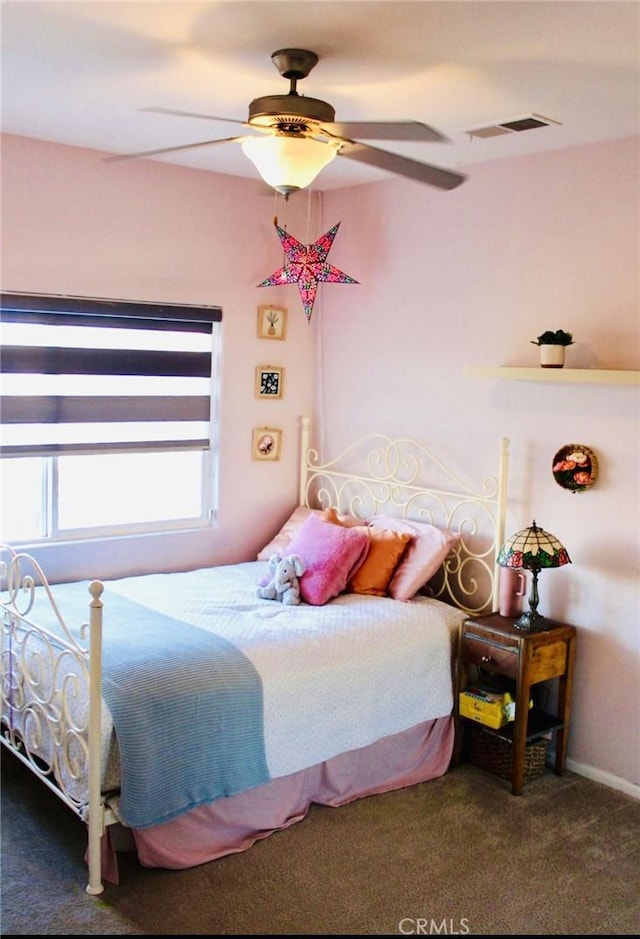 carpeted bedroom with a ceiling fan and visible vents