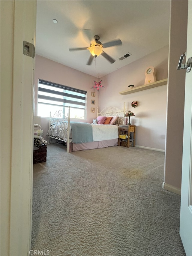 unfurnished bedroom featuring carpet floors, baseboards, visible vents, and ceiling fan