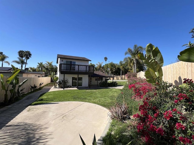 rear view of property with a patio, a lawn, and a fenced backyard