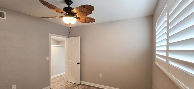 empty room featuring light wood-type flooring, baseboards, and ceiling fan