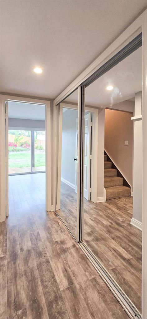 interior space with stairway, wood finished floors, and baseboards