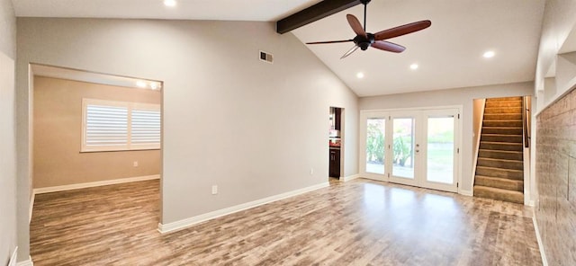 unfurnished living room featuring stairway, wood finished floors, baseboards, french doors, and beamed ceiling