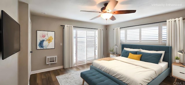 bedroom with ceiling fan, baseboards, heating unit, and wood finished floors