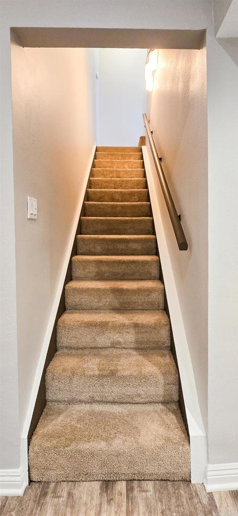 stairway with baseboards and wood finished floors