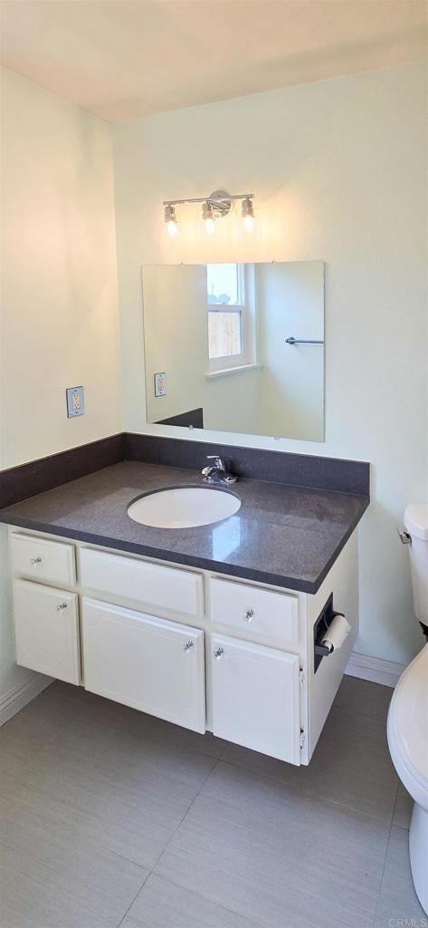 bathroom with tile patterned flooring, toilet, and vanity