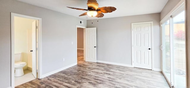 unfurnished bedroom featuring visible vents, ensuite bathroom, wood finished floors, a closet, and baseboards