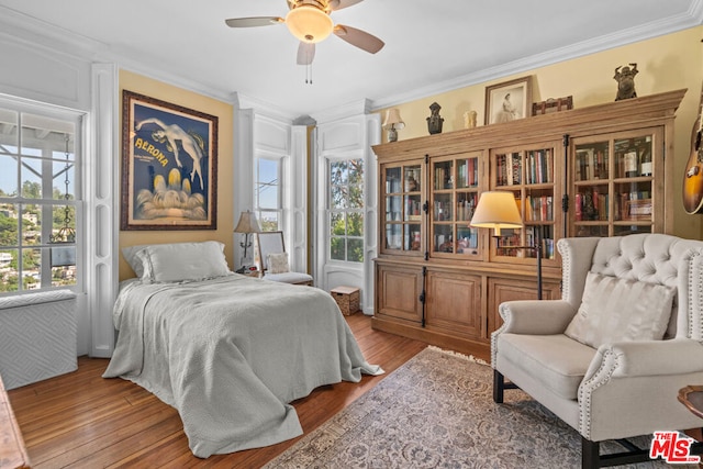 bedroom with crown molding, wood-type flooring, and ceiling fan