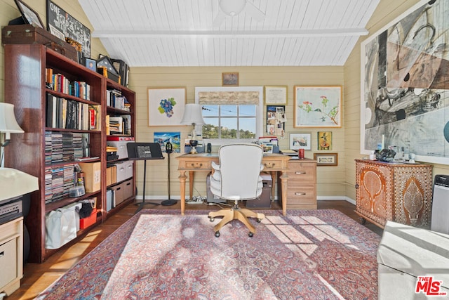 office area featuring wooden walls, dark hardwood / wood-style floors, and vaulted ceiling with beams