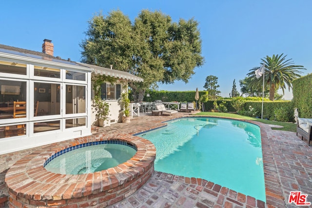 view of swimming pool with an in ground hot tub and a patio area