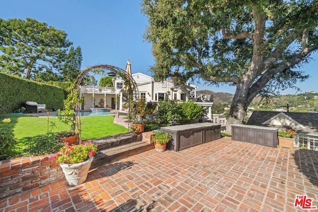 view of patio with a balcony and a fenced in pool