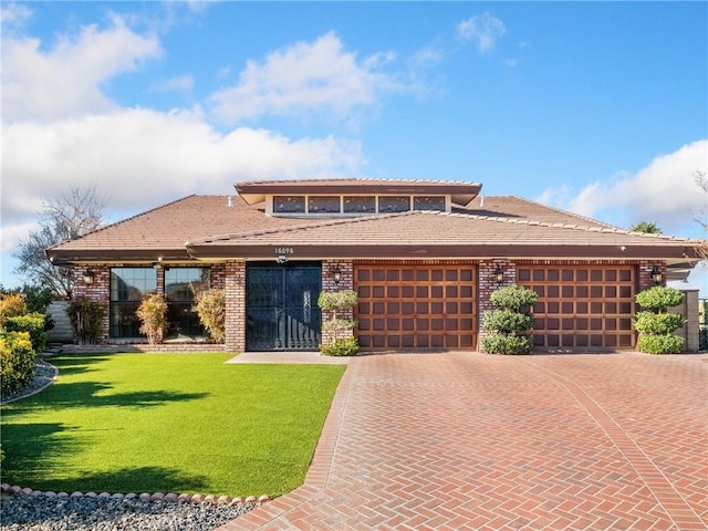 prairie-style home with a garage and a front lawn