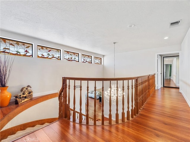 hallway with wood-type flooring and a textured ceiling