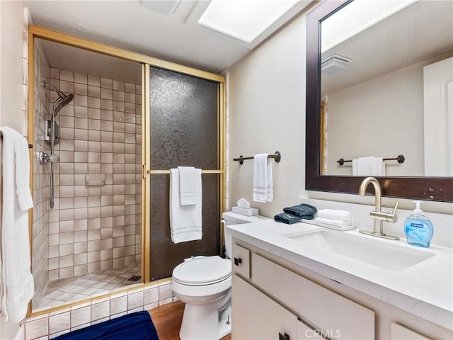 bathroom featuring vanity, wood-type flooring, walk in shower, and toilet