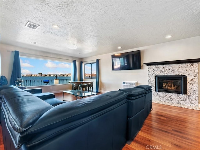 living room featuring hardwood / wood-style floors, a textured ceiling, and a fireplace