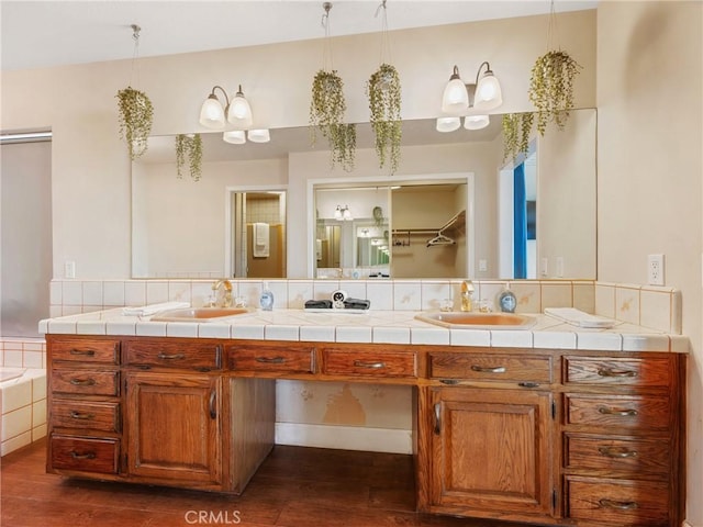 bathroom with vanity, hardwood / wood-style floors, and tiled bath