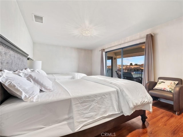 bedroom featuring hardwood / wood-style floors and access to outside