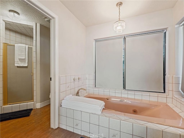 bathroom with hardwood / wood-style floors, toilet, independent shower and bath, and a textured ceiling