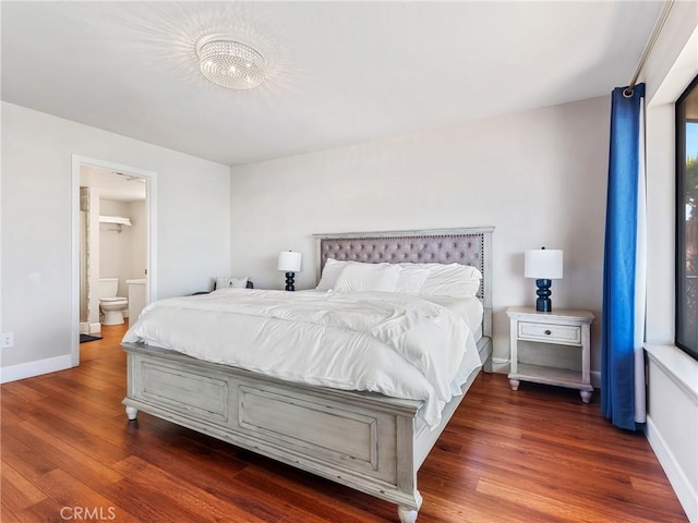 bedroom featuring ensuite bathroom and dark wood-type flooring