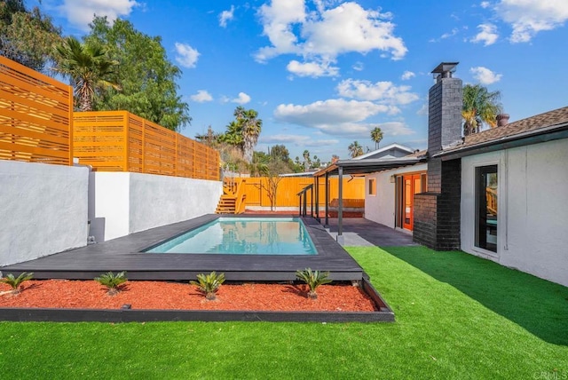 view of pool featuring a wooden deck and a yard