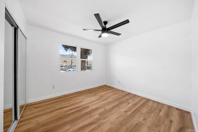 unfurnished bedroom featuring ceiling fan, light hardwood / wood-style floors, and a closet