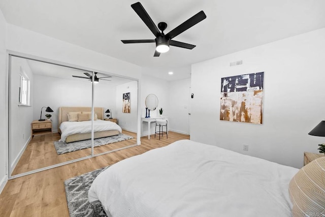 bedroom featuring hardwood / wood-style flooring, ceiling fan, and a closet