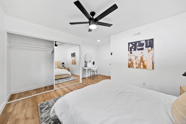 bedroom with ceiling fan, wood-type flooring, and a closet