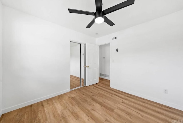 unfurnished bedroom with light hardwood / wood-style flooring, a closet, and ceiling fan