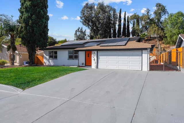 single story home with a garage, a front lawn, and solar panels