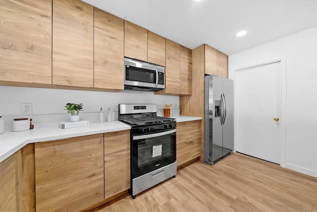 kitchen with stainless steel appliances and light hardwood / wood-style floors