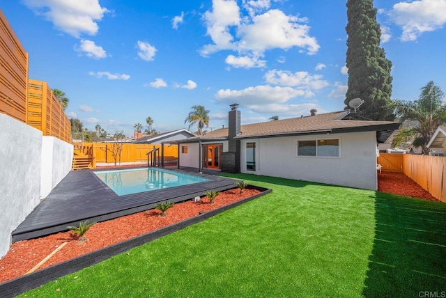 back of house with a yard and a swimming pool side deck