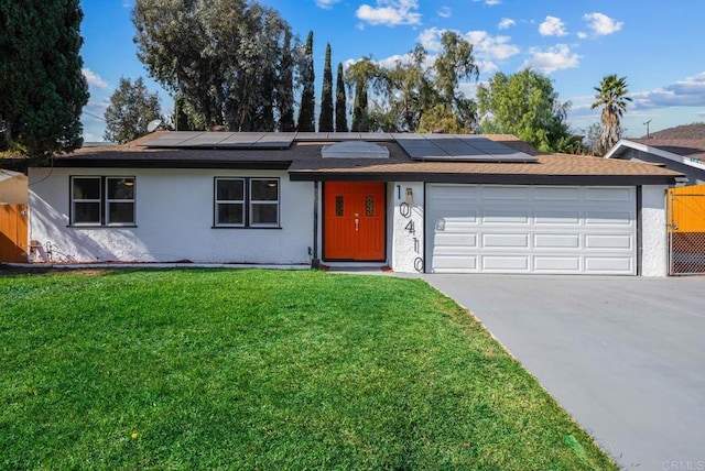 single story home with a garage, a front lawn, and solar panels